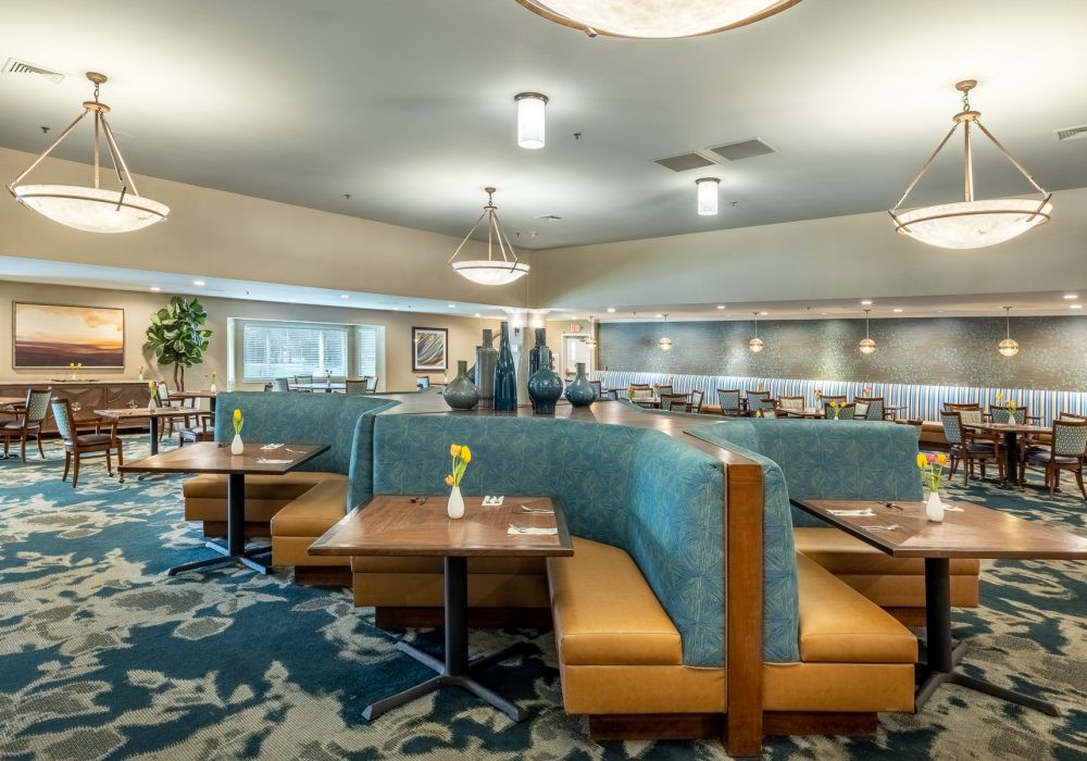 A modern restaurant interior with upholstered booths and stylish lighting fixtures.