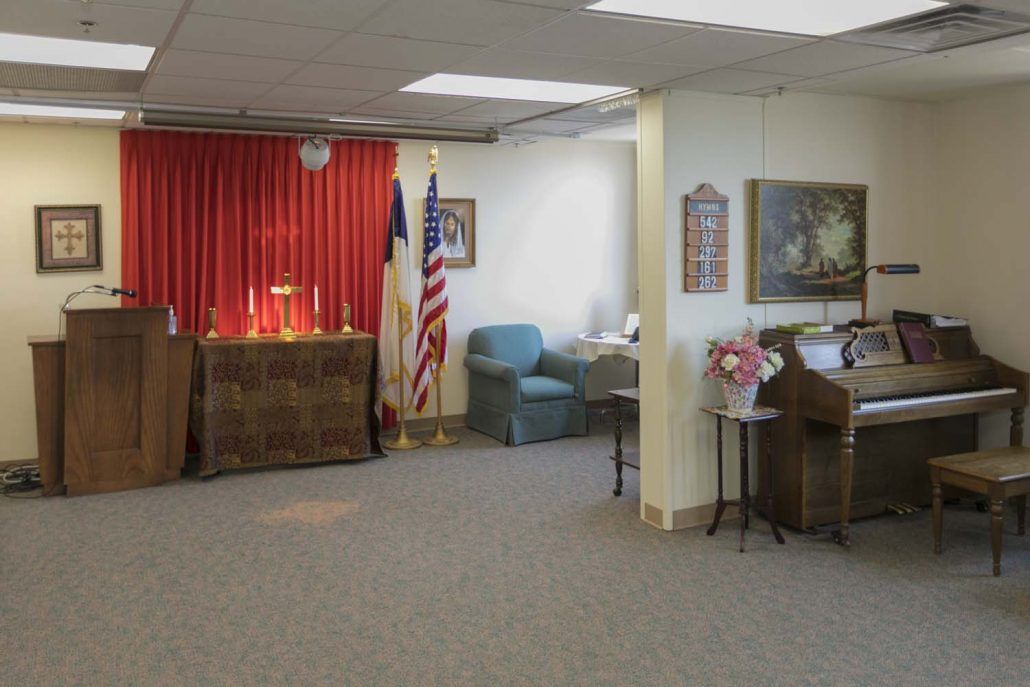 A room with red curtains, flags, and various pieces of furniture and artwork.