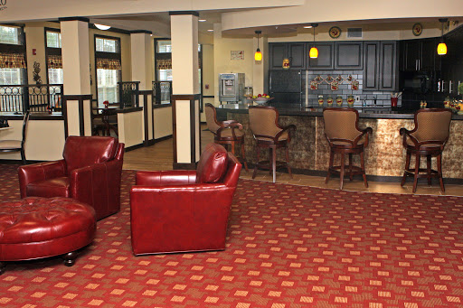 A cozy lobby area featuring red leather chairs and a bar counter, perfect for relaxing.
