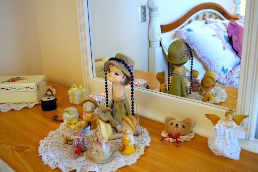 A charming display of a vintage doll and decorative items on a wooden dresser.