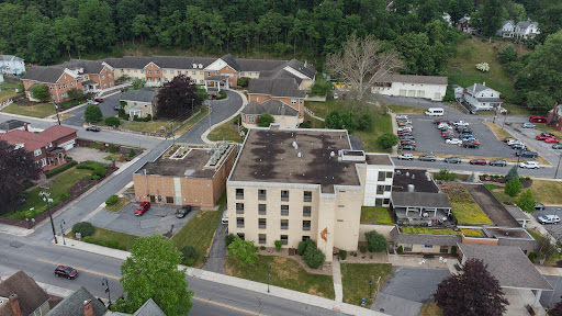 An aerial view of a suburban area showcasing various buildings and surrounding greenery.