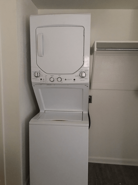 A stacked washer and dryer unit in a laundry room.