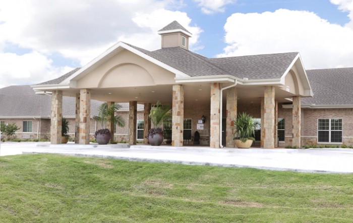 A large building with columns and a spacious lawn.