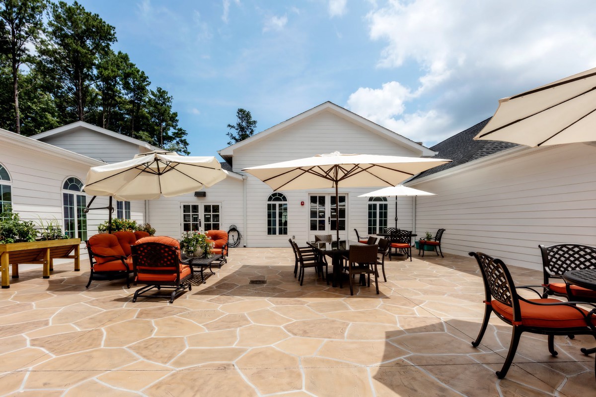 A spacious outdoor patio with seating areas and large umbrellas on a sunny day.