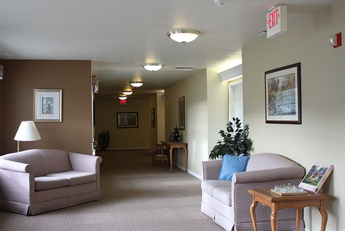 A comfortable lobby area with sofas, indoor plants, and artwork on the walls.