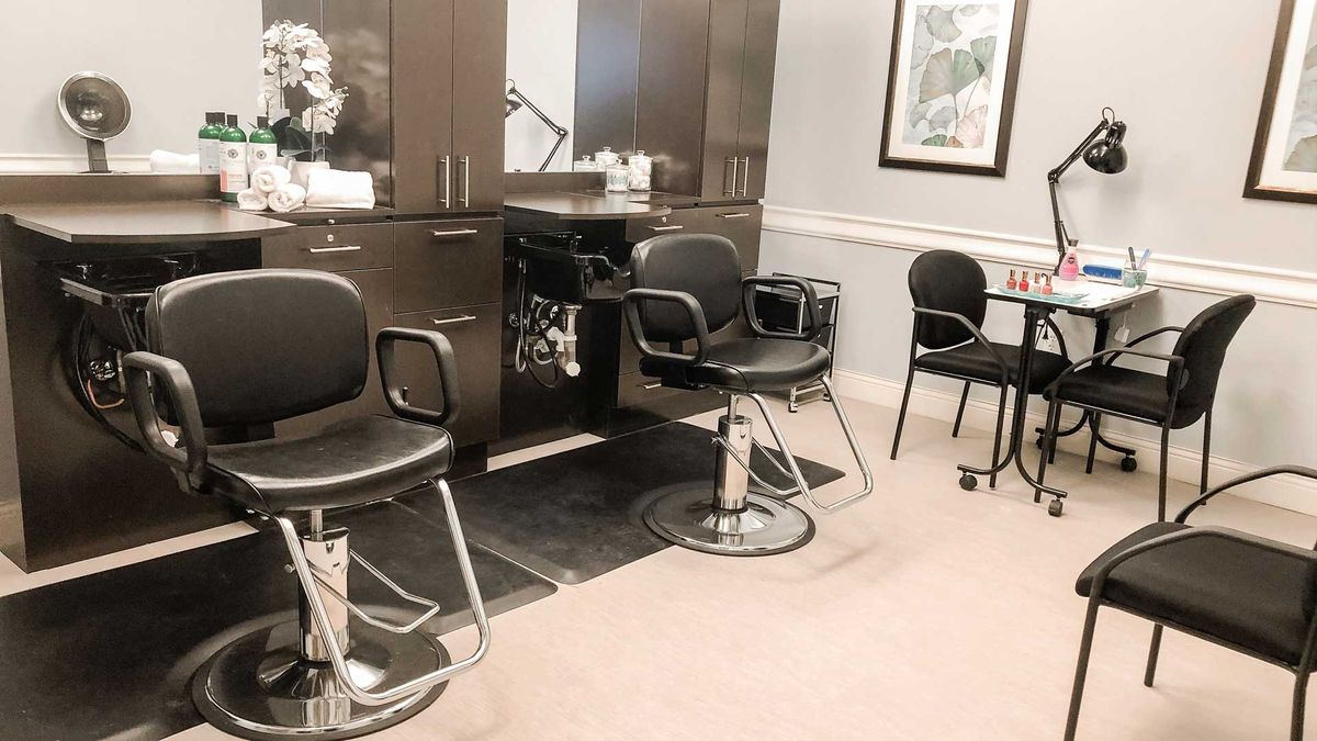 A modern hair salon interior with empty chairs and mirrors.