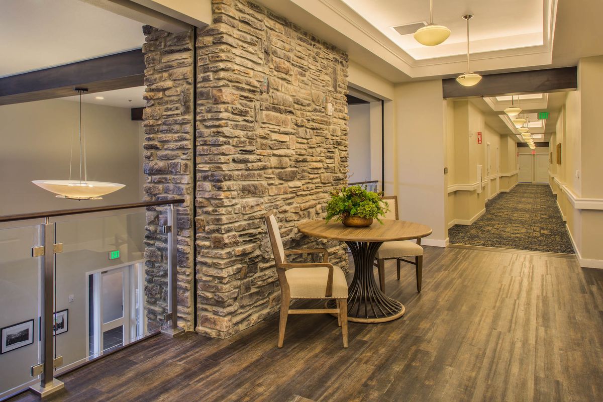 Modern hallway with stone wall and cozy seating area.