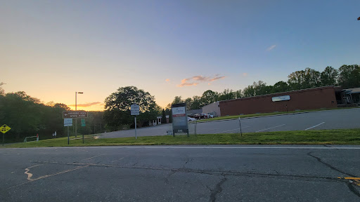 A peaceful scene at sunset, showcasing a view of a quiet road alongside buildings and trees.