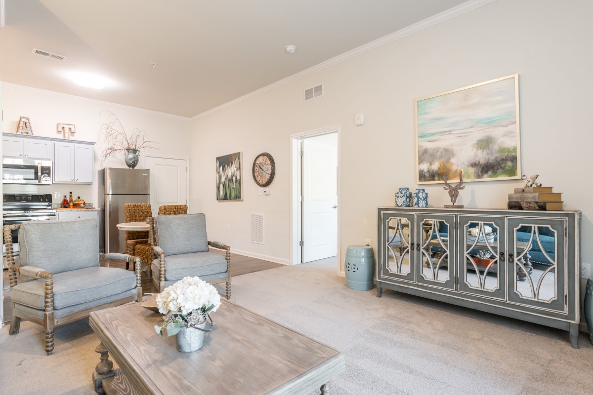 A modern living room with neutral tones, featuring elegant furniture and tasteful decor.