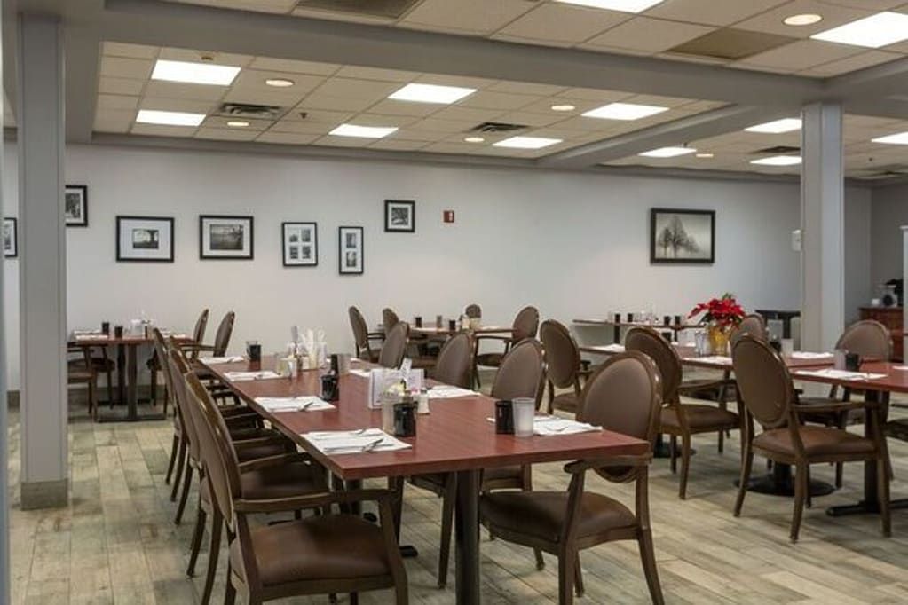 An empty restaurant dining area with neatly arranged tables and chairs.