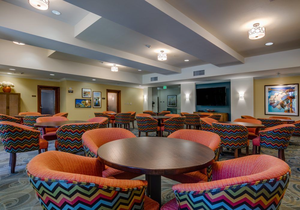 A modern lounge area with colorful seating and a large TV.
