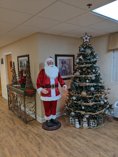 A festive holiday scene featuring a Santa Claus figure beside a beautifully decorated Christmas tree.