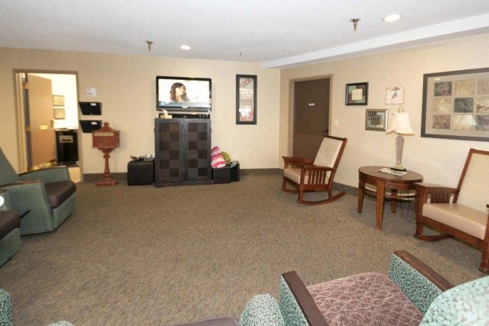 A cozy living room with a television and wooden furniture.