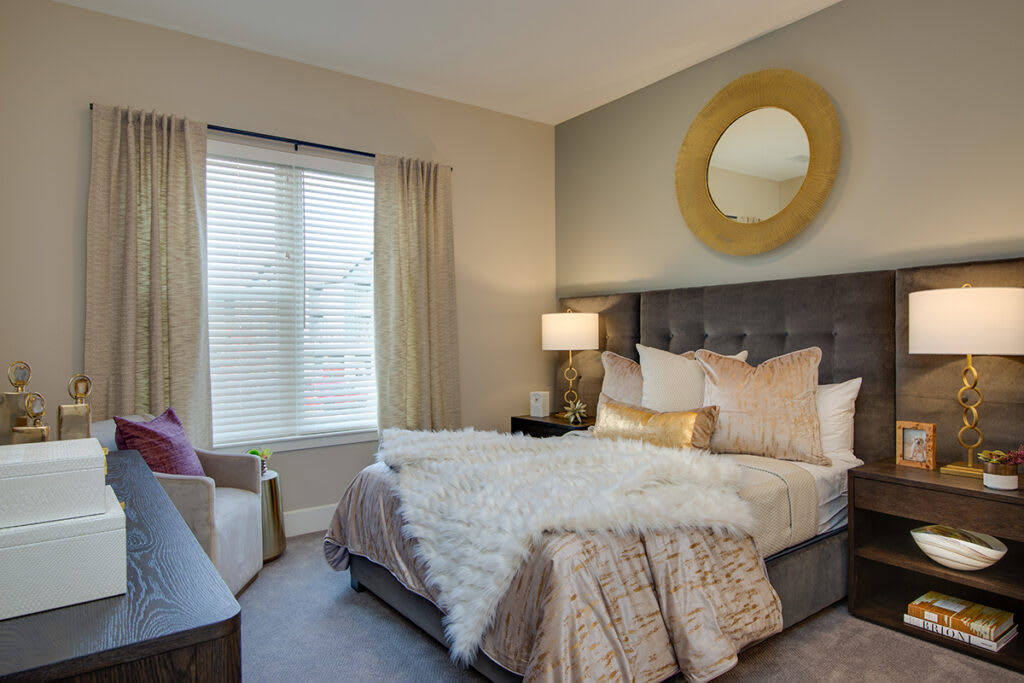 A cozy bedroom with neutral tones, featuring a plush bed and decorative elements.