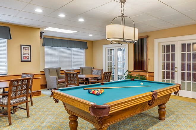 A cozy recreation room featuring a pool table and comfortable seating.