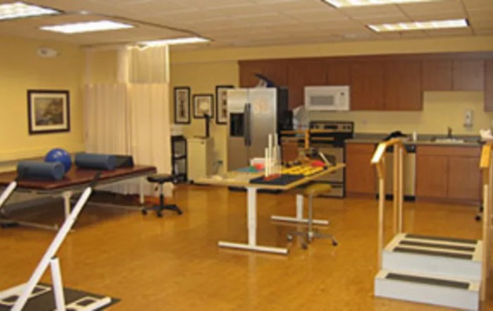 A rehabilitation center room equipped with exercise equipment and treatment tables.
