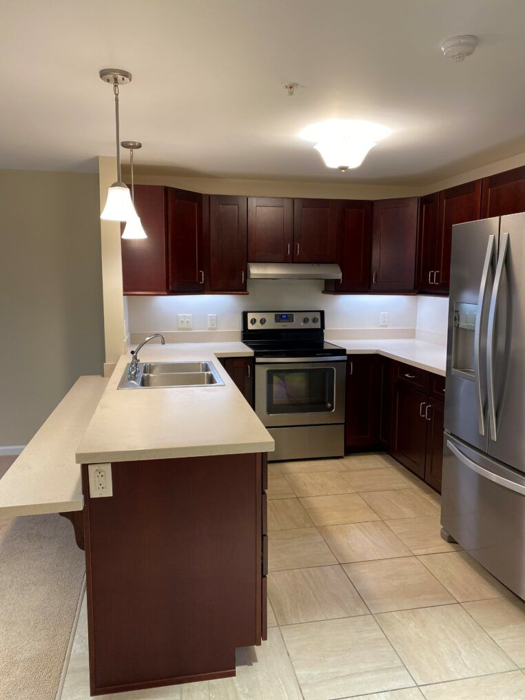 Modern kitchen with stainless steel appliances and dark wood cabinets.
