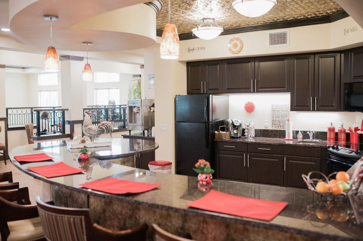 A modern kitchen interior featuring a spacious countertop with bar stools and contemporary appliances.