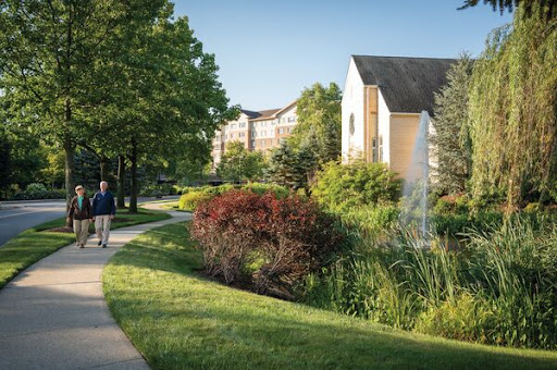 A peaceful pathway surrounded by lush greenery and modern residential buildings, inviting leisurely strolls.