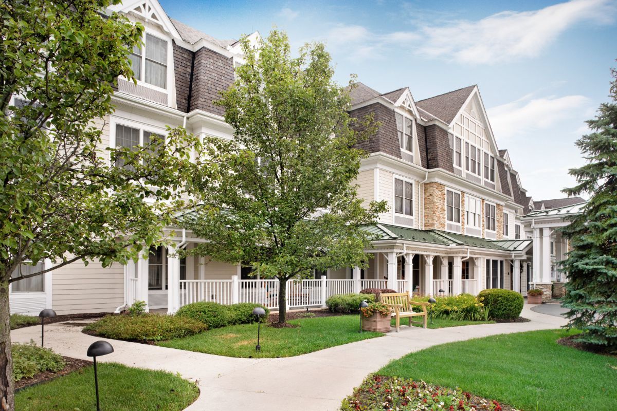 A charming residential building with manicured landscaping and a central pathway.