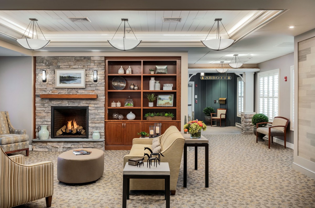 A modern and cozy living room featuring a fireplace, bookshelf, and comfortable seating area.