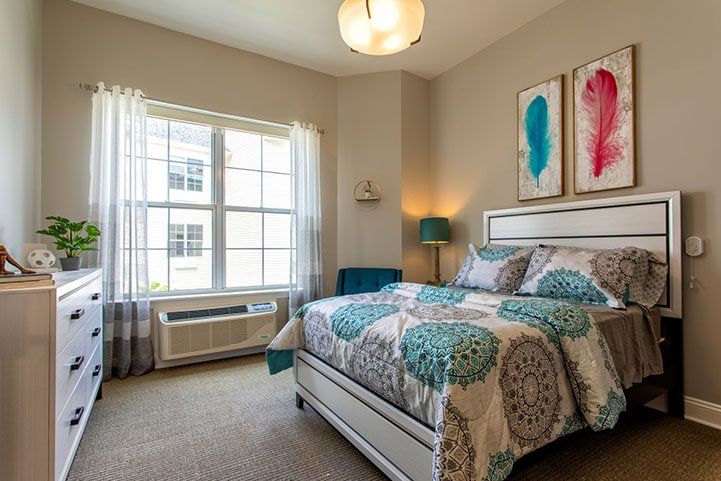 A cozy bedroom with a well-decorated interior, featuring a comfortable bed and colorful artwork.