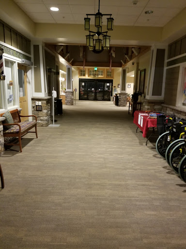 A well-lit hallway featuring seating and wheelchairs along the sides.