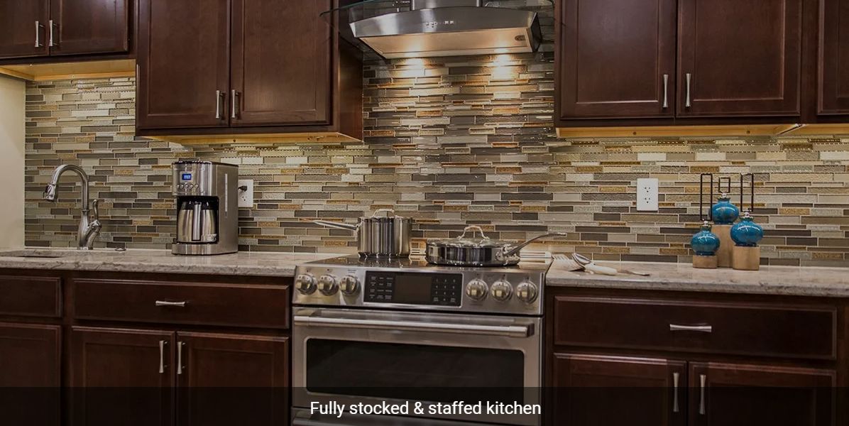 A modern kitchen with a fully stocked and staffed setup.
