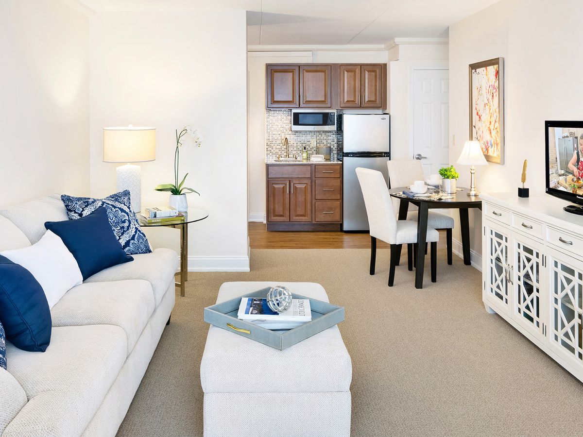 A modern living space featuring a cozy living room, compact kitchen, and dining area.