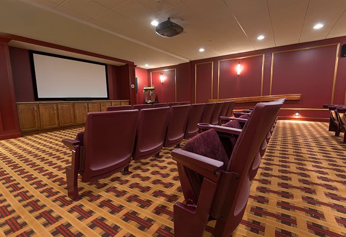 A cozy home theater with plush seating and a large screen.