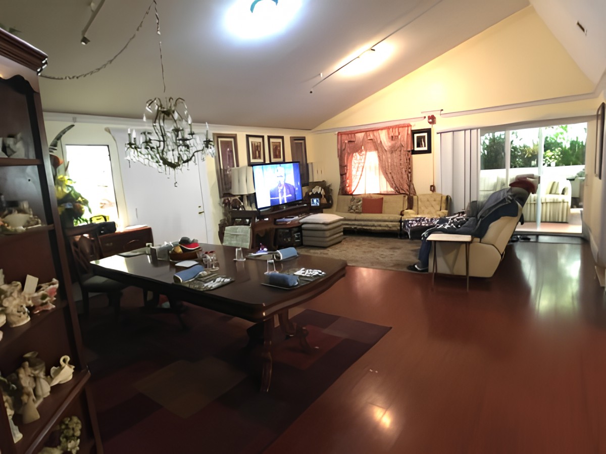 A cozy living room with a large dining table, chandelier, and comfortable seating area.