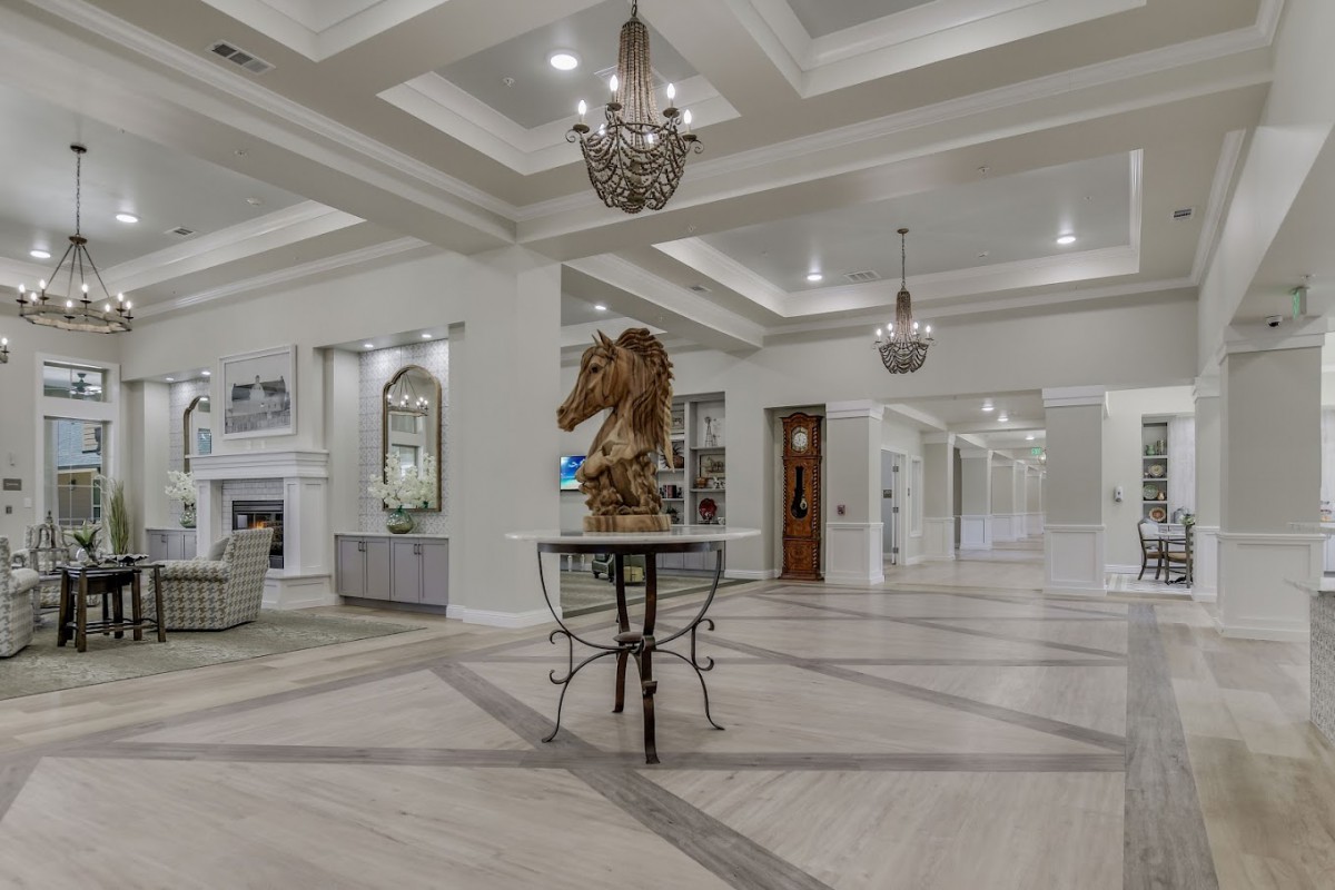 A luxurious lobby area featuring elegant chandeliers, a central sculpture on a table, and sophisticated ceiling designs.