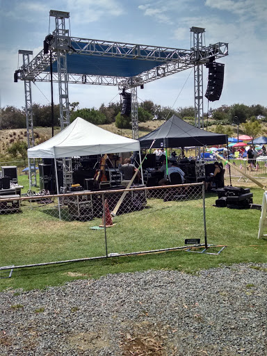 An outdoor stage setup with tents and sound equipment, ready for a performance.