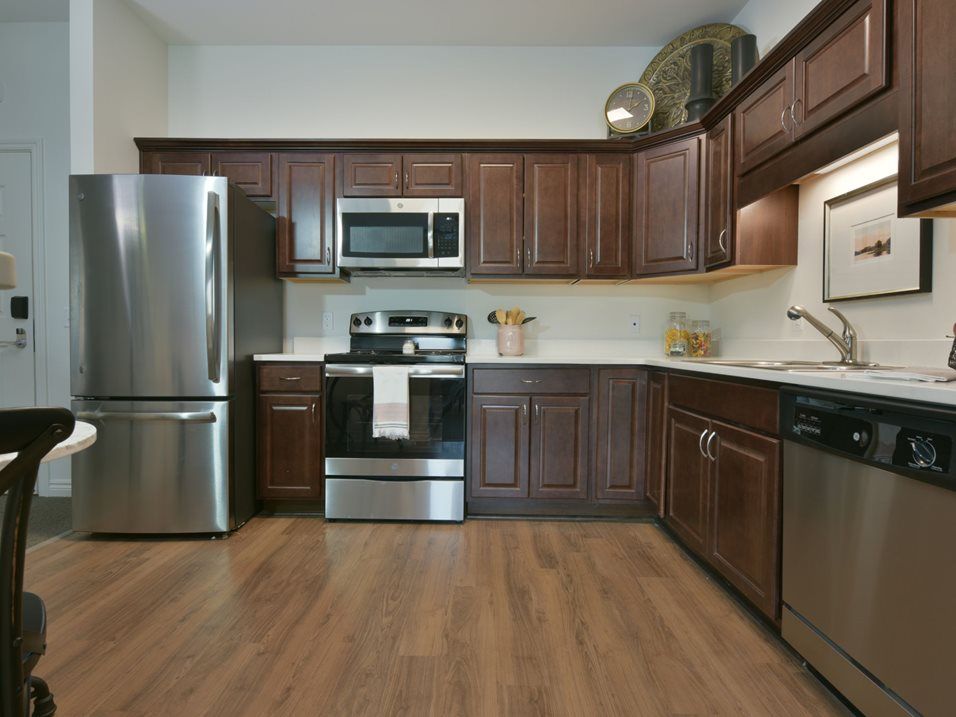 A modern kitchen with stainless steel appliances and wooden cabinets.