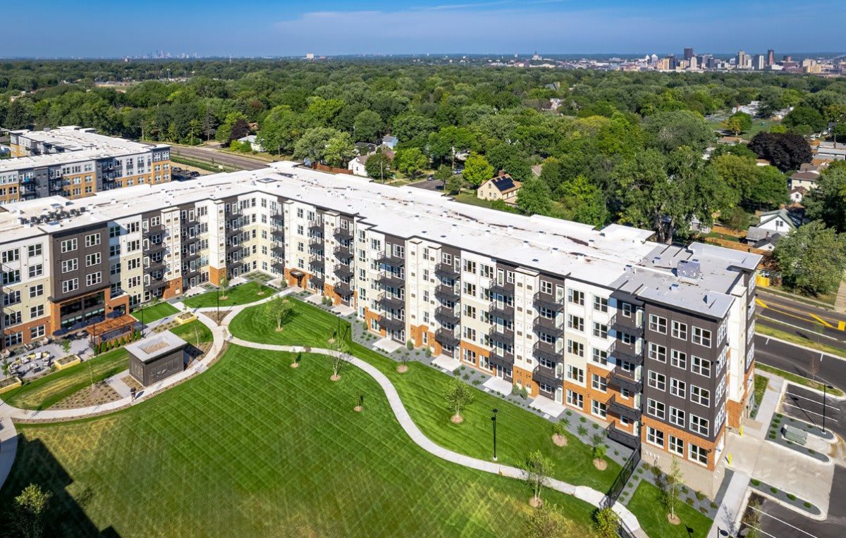 Aerial view of a modern apartment building surrounded by greenery.