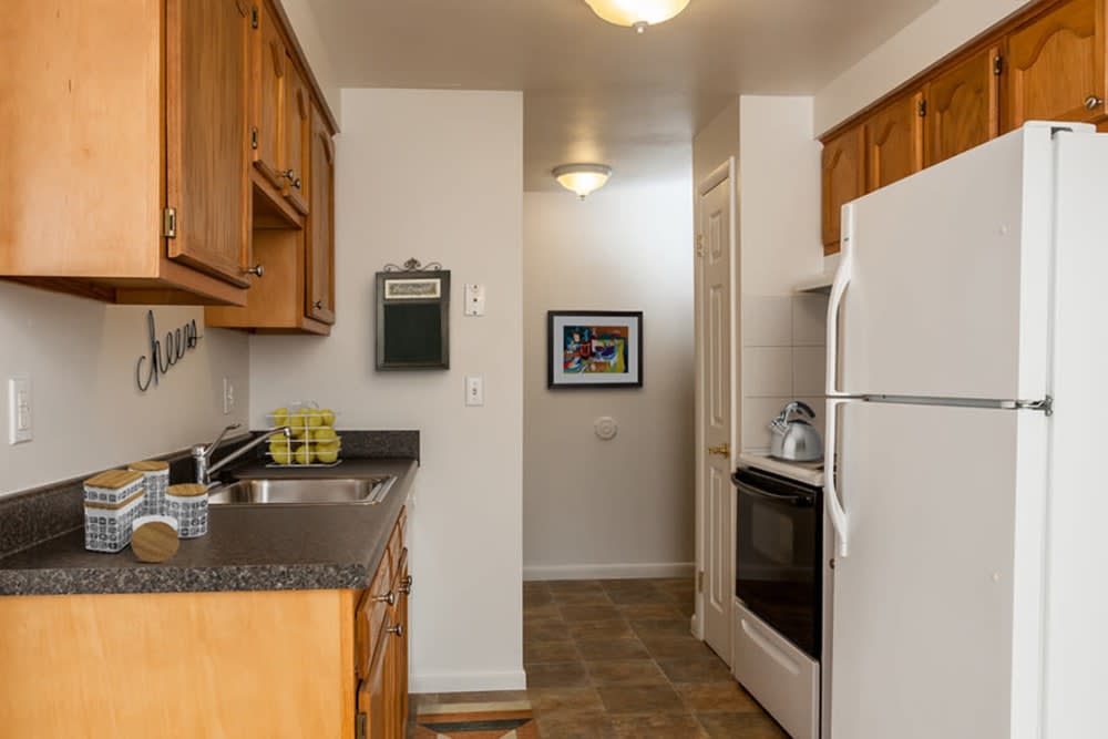 A compact, modern kitchen with wooden cabinets and essential appliances.