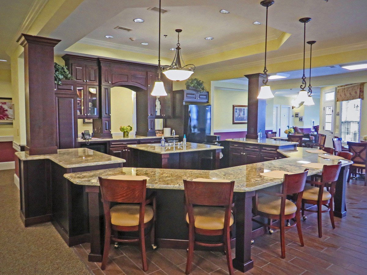 A modern kitchen interior featuring a large island with bar stools, elegant lighting, and stylish countertops.