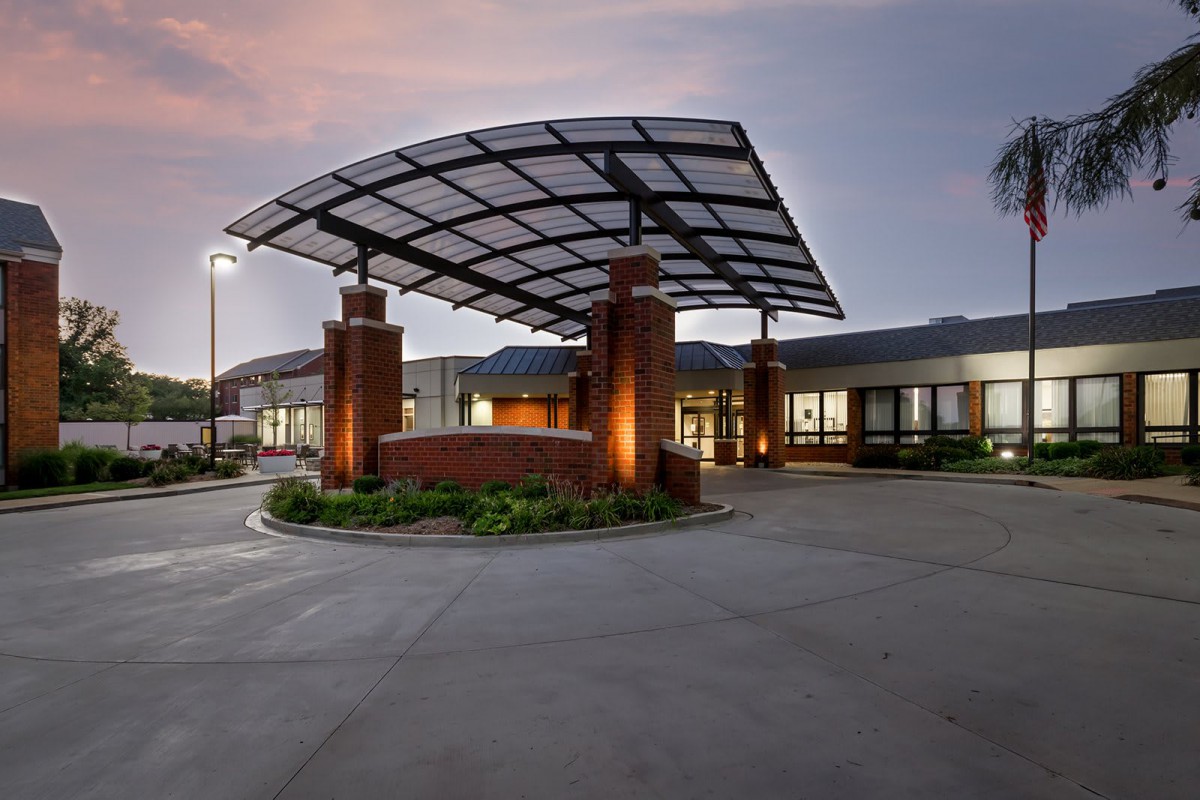 A modern building entrance illuminated in the evening light.