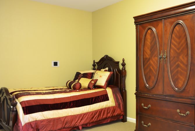 A traditional bedroom with a wooden bed and wardrobe.