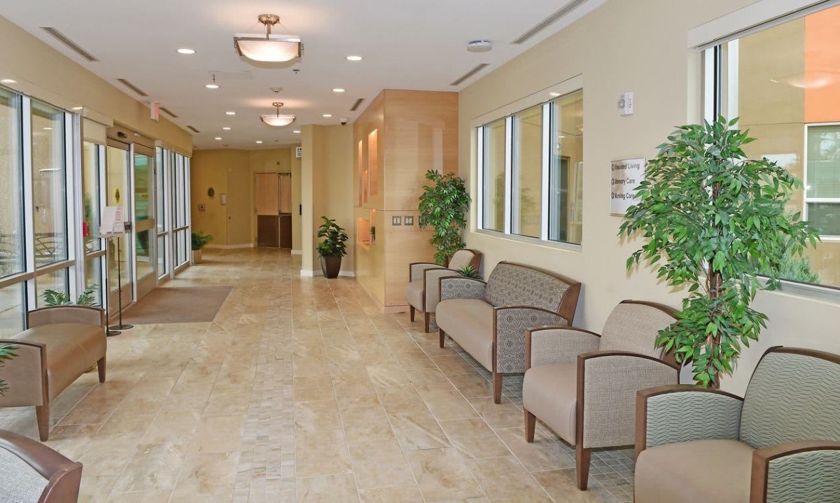 A spacious and well-lit lobby with seating and decorative plants.