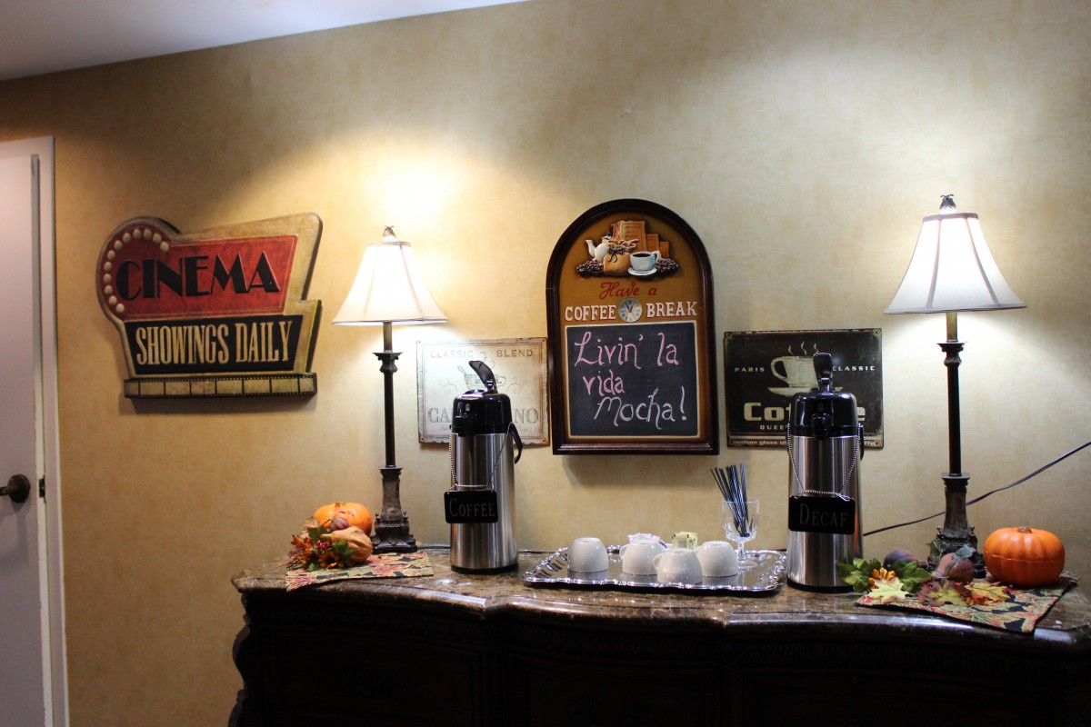 A cozy coffee station with snacks and decorative signs.