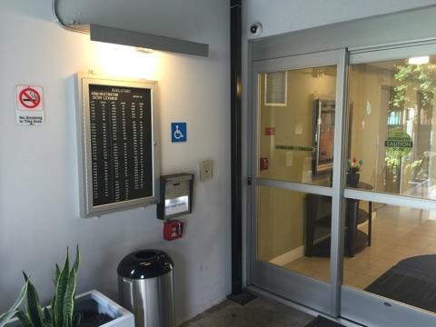 The entrance of a building featuring signage and accessibility features.