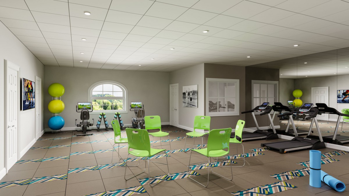 A fitness room with exercise equipment and green chairs arranged in a circle.