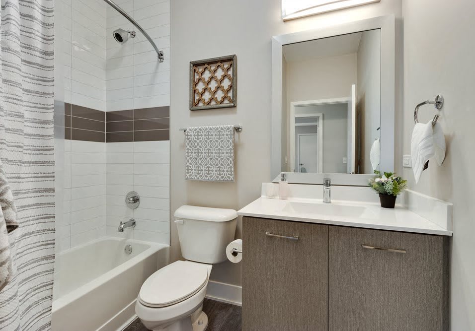 Modern bathroom with a bathtub, sink, and large mirror.