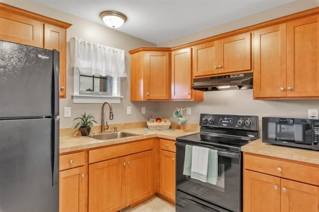 A cozy kitchen with wooden cabinets and modern appliances.