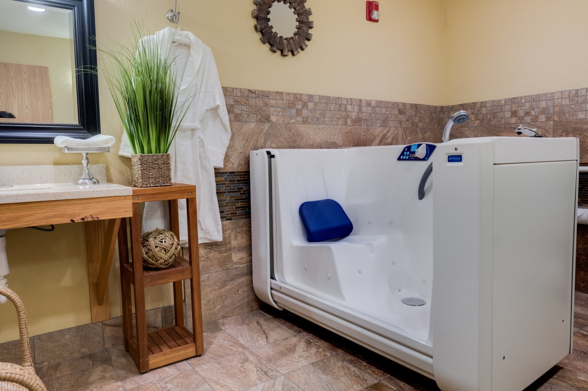 An accessible walk-in bathtub in a well-appointed bathroom setting.
