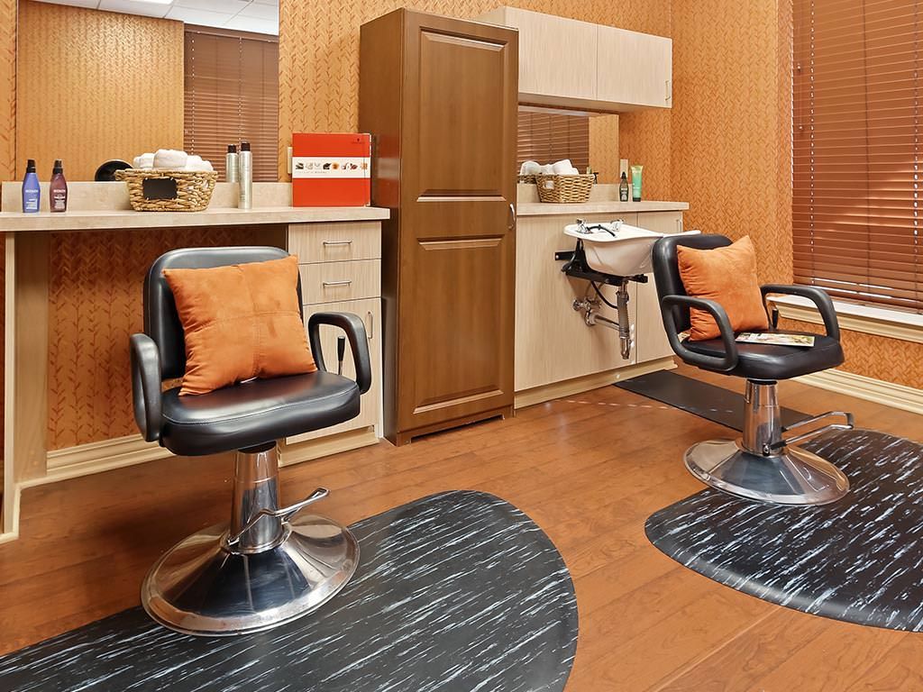 A modern barber shop interior with stylish chairs and mirrors.
