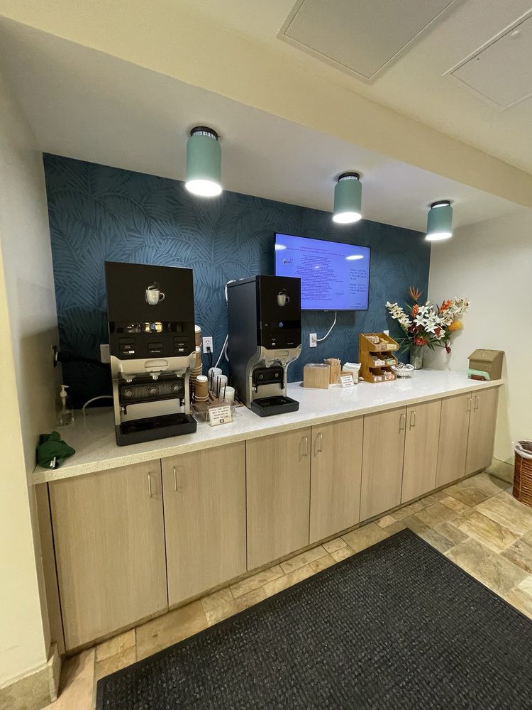 A modern self-service coffee station equipped with coffee machines, a variety of supplies, and snacks.