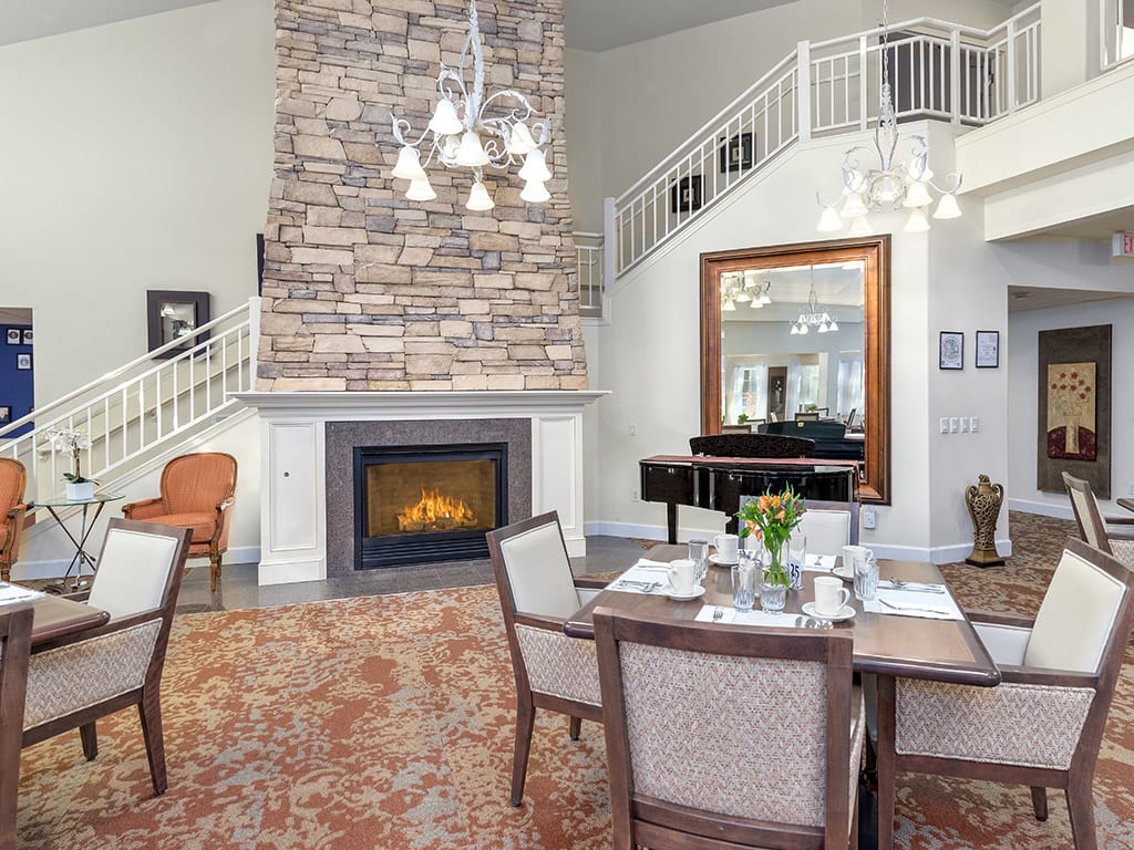 A cozy living and dining space featuring a stone fireplace and elegant furnishings.