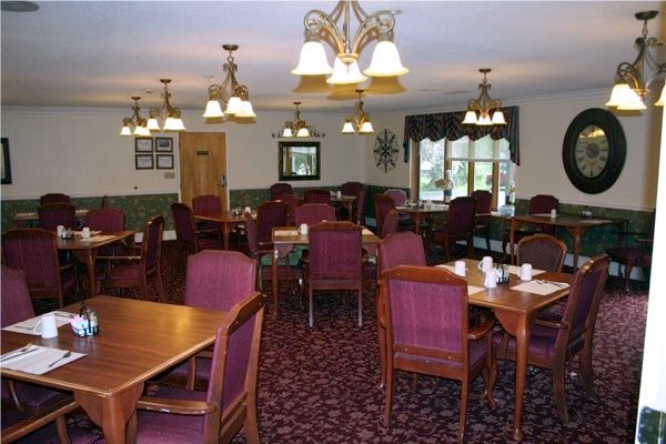 A cozy dining room with elegant lighting and neatly arranged tables and chairs.